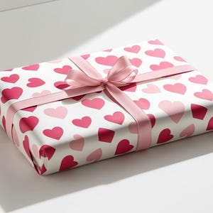 May include: A white gift box with a pink ribbon and a pattern of pink and red hearts.