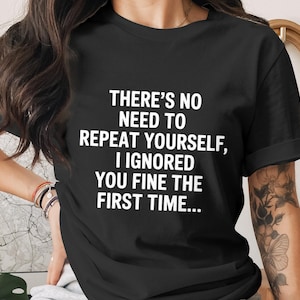 May include: Black t-shirt with the white text: "THERE'S NO NEED TO REPEAT YOURSELF, I IGNORED YOU FINE THE FIRST TIME...". The shirt has short sleeves and a crew neck.