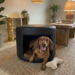 May include: A white ceramic mug with a black handle and the text "But First, Coffee" in a black, handwritten-style font. The mug is on a white surface.