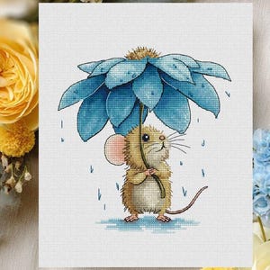 May include: Cross-stitch art of a mouse sheltering under a large blue flower umbrella in the rain. The mouse is tan with a pink ear and long whiskers. The flower has blue petals and is detailed with cross-stitch. The artwork includes the text "Vihola Cross Stitch".