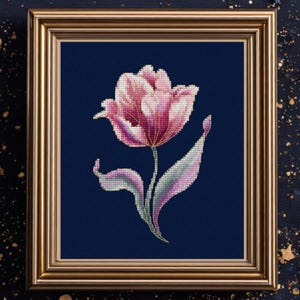 May include: A framed cross-stitch of a pink tulip against a dark blue background. The flower has detailed shading and a green stem with a curved leaf. The frame is gold-colored, and the artwork is signed "Vihola Cross Stitch".