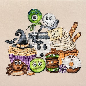 Puede incluir: Un dise&ntilde;o de punto de cruz con tem&aacute;tica de Halloween que presenta una variedad de golosinas, que incluyen cupcakes, galletas y una piruleta. El dise&ntilde;o tambi&eacute;n incluye un sombrero de bruja, un fantasma y una ara&ntilde;a.