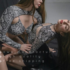 Puede incluir: Dos mujeres vistiendo tops a juego con estampado de serpiente y recortes. Los tops tienen mangas largas y un estilo ajustado. El texto "own manufacture high quality free shipping" es visible en la parte inferior de la imagen.