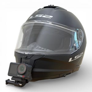 Puede incluir: Casco de moto negro mate con visera transparente y cámara de acción adjunta. El casco tiene el nombre de la marca "LS2" en letras blancas. La cámara de acción es negra y tiene el texto "ACTION 5S".