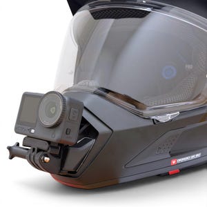 Puede incluir: Casco de moto negro con visera transparente y c&aacute;mara de acci&oacute;n adjunta. La c&aacute;mara est&aacute; montada en la parte delantera del casco y es negra con una lente y una peque&ntilde;a pantalla. El casco tiene la palabra "PRO" impresa en el lateral.