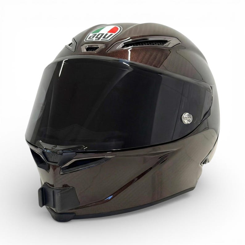Pu&ograve; includere: Casco da moto marrone e nero con visiera scura. Il casco presenta il logo "AGV" e un design aerodinamico. Questo casco &egrave; progettato per la sicurezza e la velocit&agrave;, con un focus sull'aerodinamica.