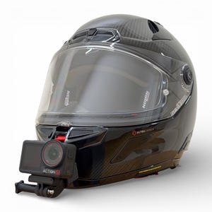May include: A black motorcycle helmet with a clear visor and an attached action camera. The helmet has a glossy finish and the camera is labeled "ACTION 5". The helmet is designed for safety and recording.