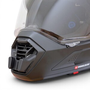 Puede incluir: Primer plano de un casco de moto negro con visera transparente. El casco presenta un sistema de ventilaci&oacute;n y la marca "LEATT" es visible. El dise&ntilde;o incluye una etiqueta roja "EMERGENCY USE ONLY".