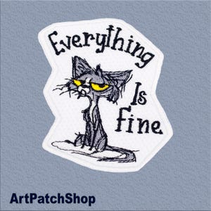 Op de afbeelding: Geborduurde patch met een chagrijnige grijze kat met gele ogen. De patch leest "Everything Is Fine" in zwarte tekst. Het heeft een witte rand op een lichtblauwe achtergrond. De tekst "ArtPatchShop" staat onderaan.