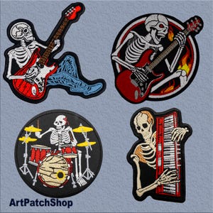 May include: Four embroidered iron-on patches featuring skeletons playing musical instruments. The patches are circular and feature a skeleton playing a guitar, a skeleton playing a guitar with flames, a skeleton playing drums, and a skeleton playing a keyboard.