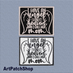 Puede incluir: Dos parches bordados con el texto "I HAVE AN angel IN heaven, AND I CALL HER mom". Uno es negro con texto blanco, el otro es blanco con texto negro. Los parches tienen forma cuadrada con esquinas redondeadas y diseños de alas de ángel.