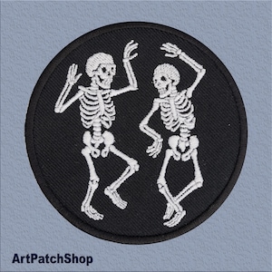 Può includere: Toppa ricamata con due scheletri bianchi che ballano su uno sfondo circolare nero. Gli scheletri sono dettagliati con gabbie toraciche, teschi e arti. La toppa ha il testo "ArtPatchShop" in basso.
