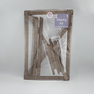 May include: A wooden weaving loom kit with a label that reads "Weaving Kit" and a website address. The kit includes a wooden frame, a shuttle, and a heddle.