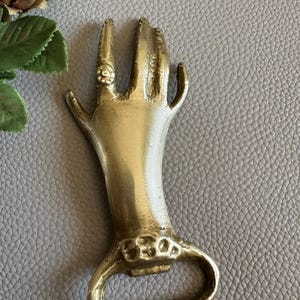 Brass bottle opener in the form of a Hand