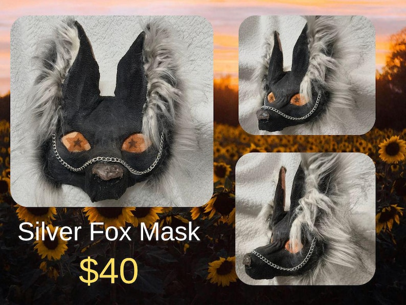 May include: A silver fox mask with black ears and face, orange eyes, and a silver chain. The mask is surrounded by fluffy, gray fur. The text "Silver Fox Mask" is visible.