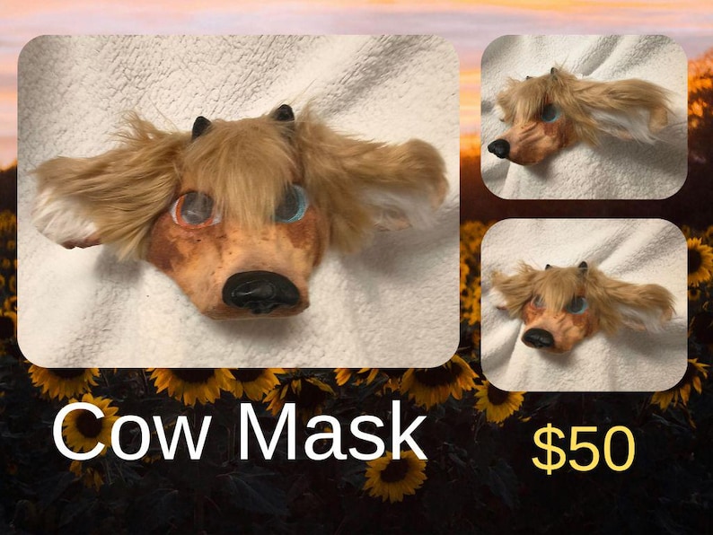 May include: A cow mask with a brown and tan face, black horns, and long, light brown fur. The mask has blue and orange eyes and a black nose. The text "Cow Mask" is displayed in white.