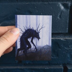 Puede incluir: Una criatura negra y morada con cuernos y una cola larga camina por un bosque brumoso. La criatura est&aacute; representada en un estilo oscuro y sombr&iacute;o.