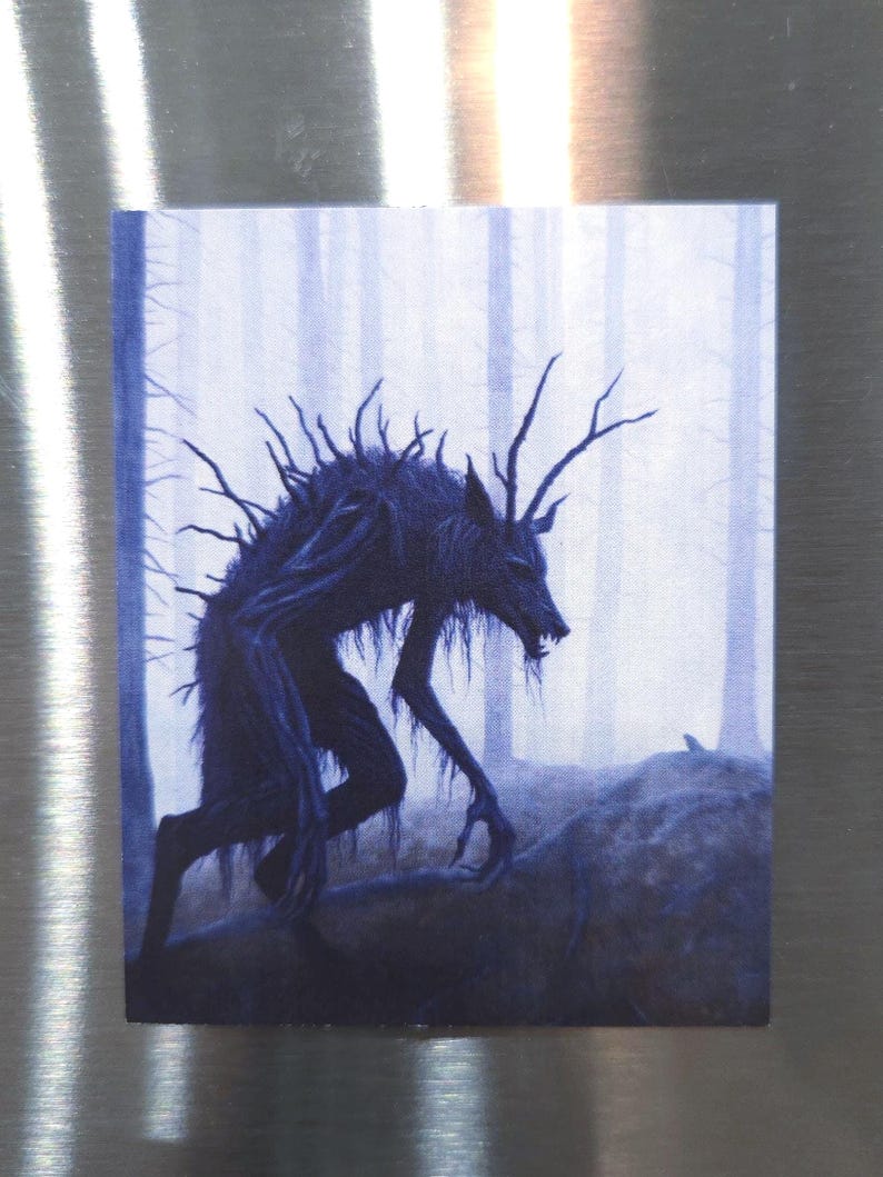 Puede incluir: Una criatura oscura y azul, con ramas que le salen del cuerpo, camina por un bosque brumoso. La criatura tiene una cabeza de lobo y garras afiladas.