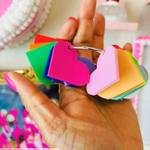 Op de afbeelding: Een verzameling kleurrijke hartvormige tags aan een zilveren ring. De tags zijn in verschillende kleuren, waaronder roze, oranje, groen en paars. De woorden "Digital Download" zijn linksonder zichtbaar.