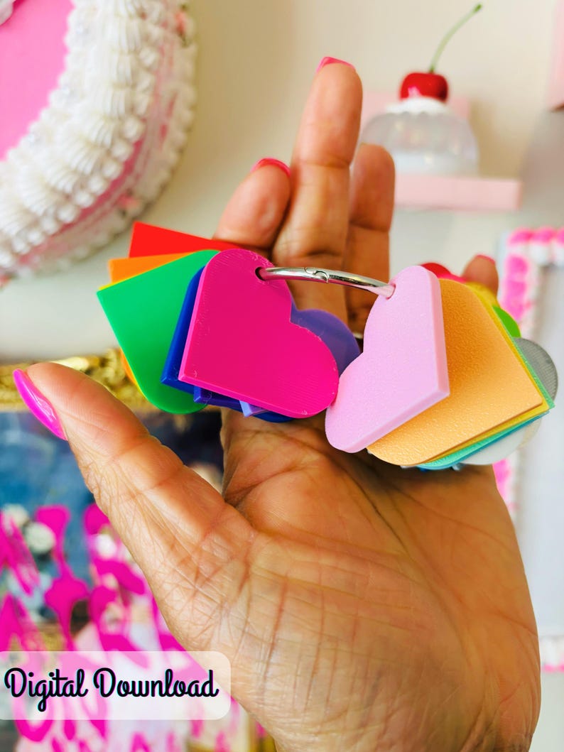 Puede incluir: Un conjunto de etiquetas en forma de coraz&oacute;n de varios colores, unidas a un anillo plateado. Las etiquetas incluyen rosa, naranja, verde y morado. Las palabras "Digital Download" son visibles en la esquina inferior izquierda.