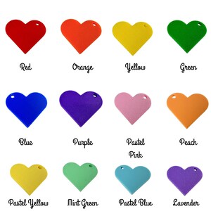 Puede incluir: Una colecci&oacute;n de etiquetas en forma de coraz&oacute;n en varios colores, incluyendo rojo, naranja, amarillo, verde, azul, morado, rosa, melocot&oacute;n, amarillo pastel, verde menta, azul pastel y lavanda. Cada etiqueta tiene un agujero y un nombre de color.