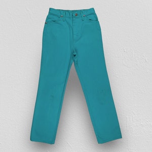 May include: A pair of teal blue jeans. The jeans have a classic straight leg style and a high waist.