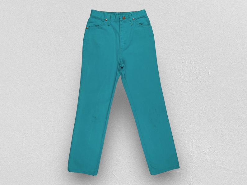 May include: A pair of teal blue jeans. The jeans have a classic straight leg style and a high waist.