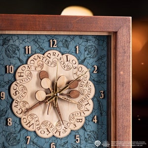Puede incluir: Un reloj de madera con fondo azul y un diseño único. La esfera del reloj presenta un diseño circular con los números del 1 al 12 y palabras como "dentista", "prisión", "escuela" y "bosque" dispuestas en forma circular. Las manecillas del reloj son de metal dorado.