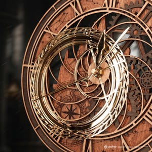 Puede incluir: Un reloj de madera con un diseño detallado que presenta números romanos, engranajes y una rosa de los vientos. El reloj tiene manecillas doradas y un anillo decorativo dorado alrededor de la esfera. El reloj está hecho de madera y tiene un acabado marrón oscuro.