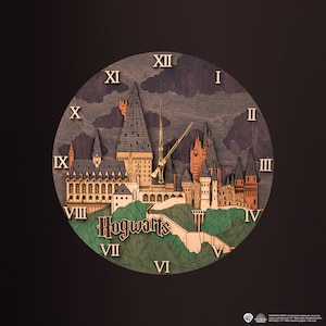 Puede incluir: Un reloj de madera con un diseño 3D del castillo de Hogwarts. La esfera del reloj está rodeada de números romanos y el castillo está rodeado de árboles verdes. El reloj dice "Hogwarts" en la parte inferior.