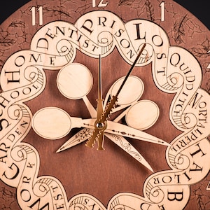 May include: Wooden wall clock with a brown background and light wood accents. The clock face features stylized text and decorative hands. The clock's design includes the words "Prison", "Lost", "Quidditch", and "Mortalperil".