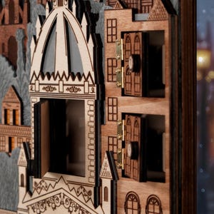 Op de afbeelding: Een houten adventskalender in de vorm van een gedetailleerde gebouwgevel. De kalender heeft openbare deuren en ramen, die een glimp van het interieur onthullen. Het ontwerp bevat ingewikkelde uitgesneden details en een gelaagde constructie.