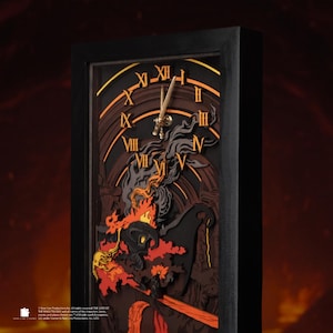 May include: A black framed clock with a layered design featuring Roman numerals and a sword-shaped clock hand. The clock face has a dark brown and orange colour scheme with a fiery graphic at the bottom. The clock is a decorative item.
