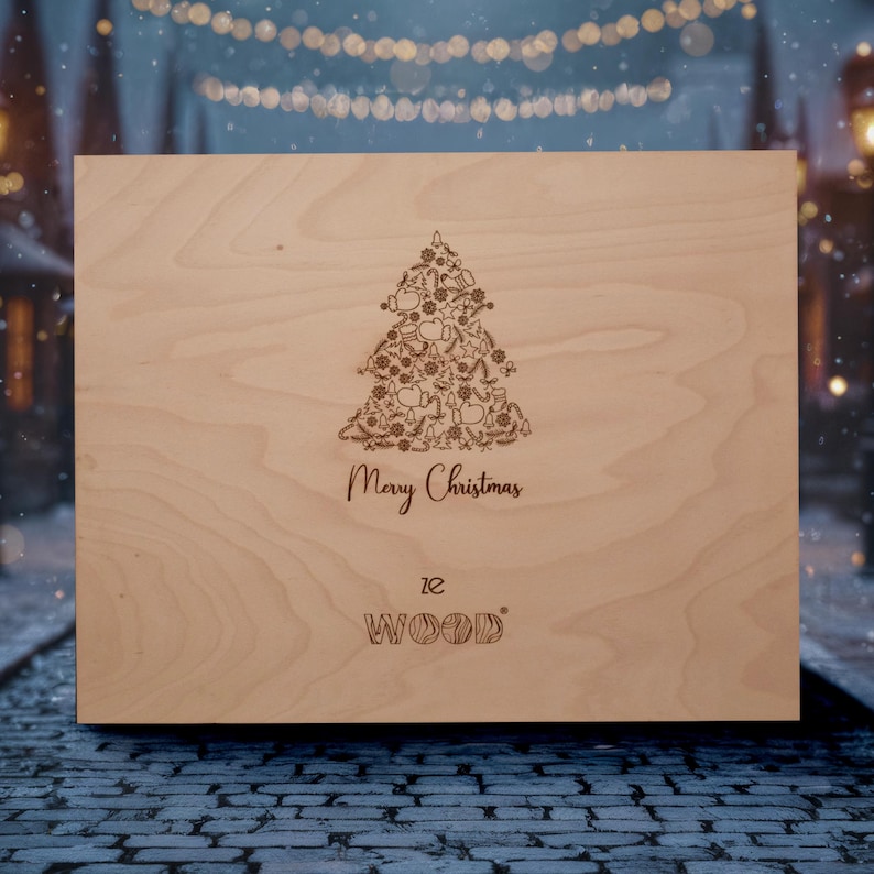 Op de afbeelding: Een lichtgekleurde houten kist met een kerstboomontwerp ge&euml;tst op de voorkant. De boom bestaat uit verschillende vakantie-thema vormen. De woorden "Merry Christmas" staan onder de boom, met de merknaam "12 WOOD" eronder.