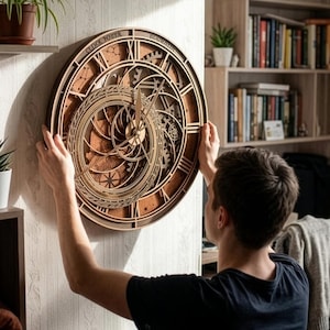 Puede incluir: Un reloj de madera circular con un diseño en capas, números romanos y engranajes intrincados. El reloj tiene las palabras "Clock Tower" y "Hogwarts" en la esfera. El reloj se sostiene contra una pared.