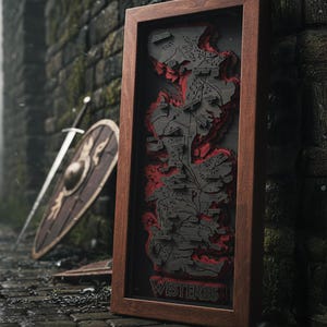 May include: A framed, layered map of Westeros, featuring a dark gray and red color scheme. The map is encased in a brown wooden frame, with the word "Westeros" at the bottom. A sword and shield are in the background.