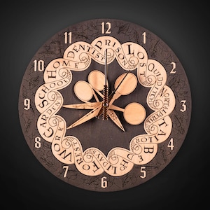 Puede incluir: Un reloj de madera redondo con una esfera gris oscuro y manecillas y n&uacute;meros de color marr&oacute;n claro. El reloj presenta adornos decorativos con palabras como "HOME", "SCHOOL" y "HOLIDAY". Las manecillas del reloj tienen forma de estrella.