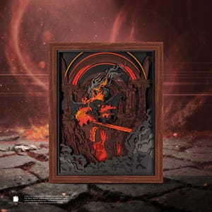 May include: A framed, layered paper art piece depicting a fiery scene with a figure wielding a sword. The artwork features shades of red, orange, and black, with a dark brown wooden frame. The scene evokes a fantasy theme.