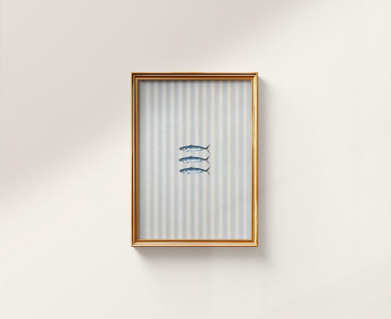 K&ouml;nnte beinhalten: Ein rechteckiger Wandkunstdruck in einem goldenen Rahmen mit einem vertikal gestreiften hellblauen und wei&szlig;en Hintergrund und drei kleinen, detaillierten Illustrationen von blauen Fischen, die horizontal in der Mitte angeordnet sind.