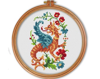 May include: A cross-stitch embroidery of a red and blue dragon with green leaves and red flowers in a wooden embroidery hoop.