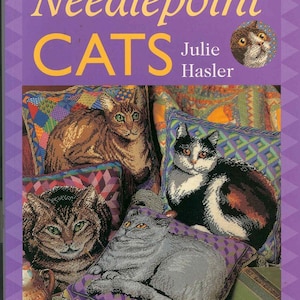 以下が含まれることがあります： ジュリー・ハスラー著「ニードルポイント・キャッツ」というタイトルの本。カラフルな表紙には、ニードルポイントの猫のクッションの画像が掲載されています。