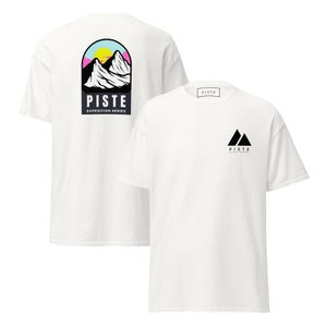 Puede incluir: Camisetas blancas con la palabra "PISTE" y un gráfico de montaña. Una camiseta tiene el gráfico en la espalda con una cordillera, un sol y las palabras "Expedition Series". La otra camiseta tiene un pequeño gráfico de montaña en la parte delantera.