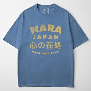 May include: Blue t-shirt with a yellow graphic that says "NARA JAPAN" in large letters, with Japanese characters and "NARA DEER PARK" below. The shirt is a Comfort Colors brand, size XL-TG-XG.