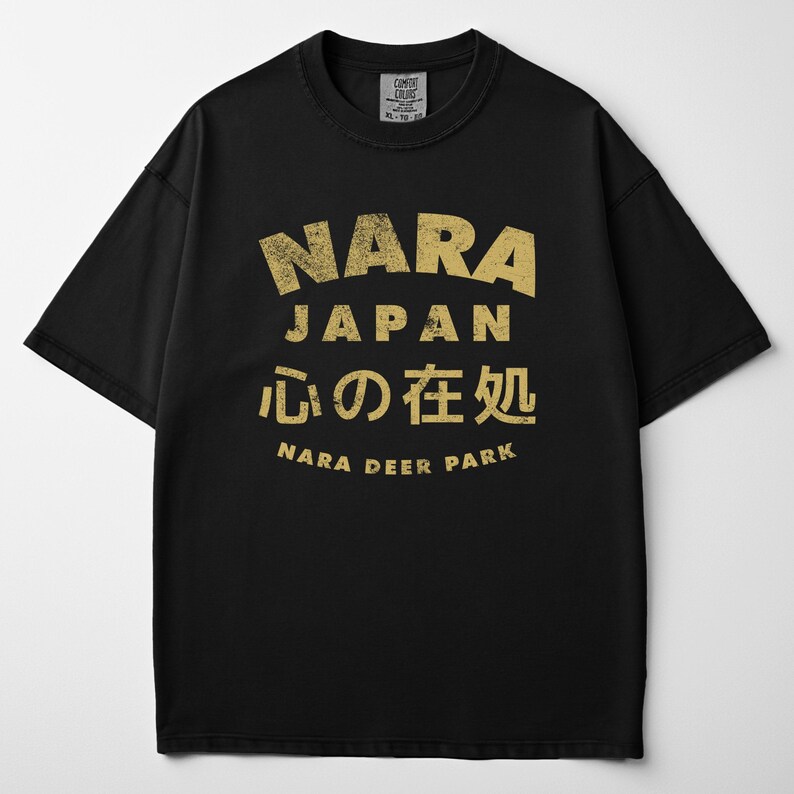 May include: Black t-shirt with a distressed gold graphic. The graphic includes the text "NARA JAPAN" in a bold font, Japanese characters, and "NARA DEER PARK". The shirt is a Comfort Colors XL-TG.