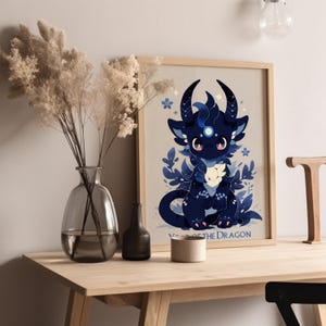 Pu&ograve; includere: Una stampa incorniciata con un drago di cartone animato blu e nero con una luna bianca sulla fronte. Il drago &egrave; circondato da fiori e foglie blu e bianche. Il testo "Anno del Drago" &egrave; in fondo alla stampa.