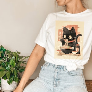 ラーメン猫Tシャツ、黒猫ラーメンTシャツ、日本料理Tシャツ、かわいいグラフィックTシャツ、ミレスガル黒猫ギフト