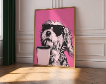 Puede incluir: Una impresión artística enmarcada que muestra un perro con gafas de sol y sosteniendo una taza de café. El perro está representado en blanco y negro sobre un fondo rosa brillante. El marco es dorado y la obra de arte se exhibe en una habitación con suelo de parquet.