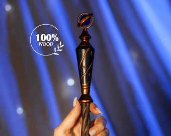 May include: A wooden wand with a gold-colored metal tip and a blue orb on top. The wand is twisted and has a dark brown finish. The text "100% WOOD" is visible in the image.