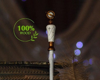 May include: A white wooden wand with a gold-colored top and a small globe. The wand is decorated with stars and is standing upright on a white surface. The text "100% WOOD" is visible in the image.