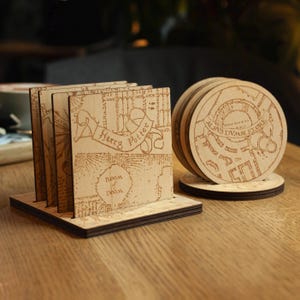 May include: Wooden coaster set featuring a map design with the text "Harry Potter" and "Room of Doom". The set includes square and round coasters, all with a light brown finish. The coasters are displayed on a wooden table.